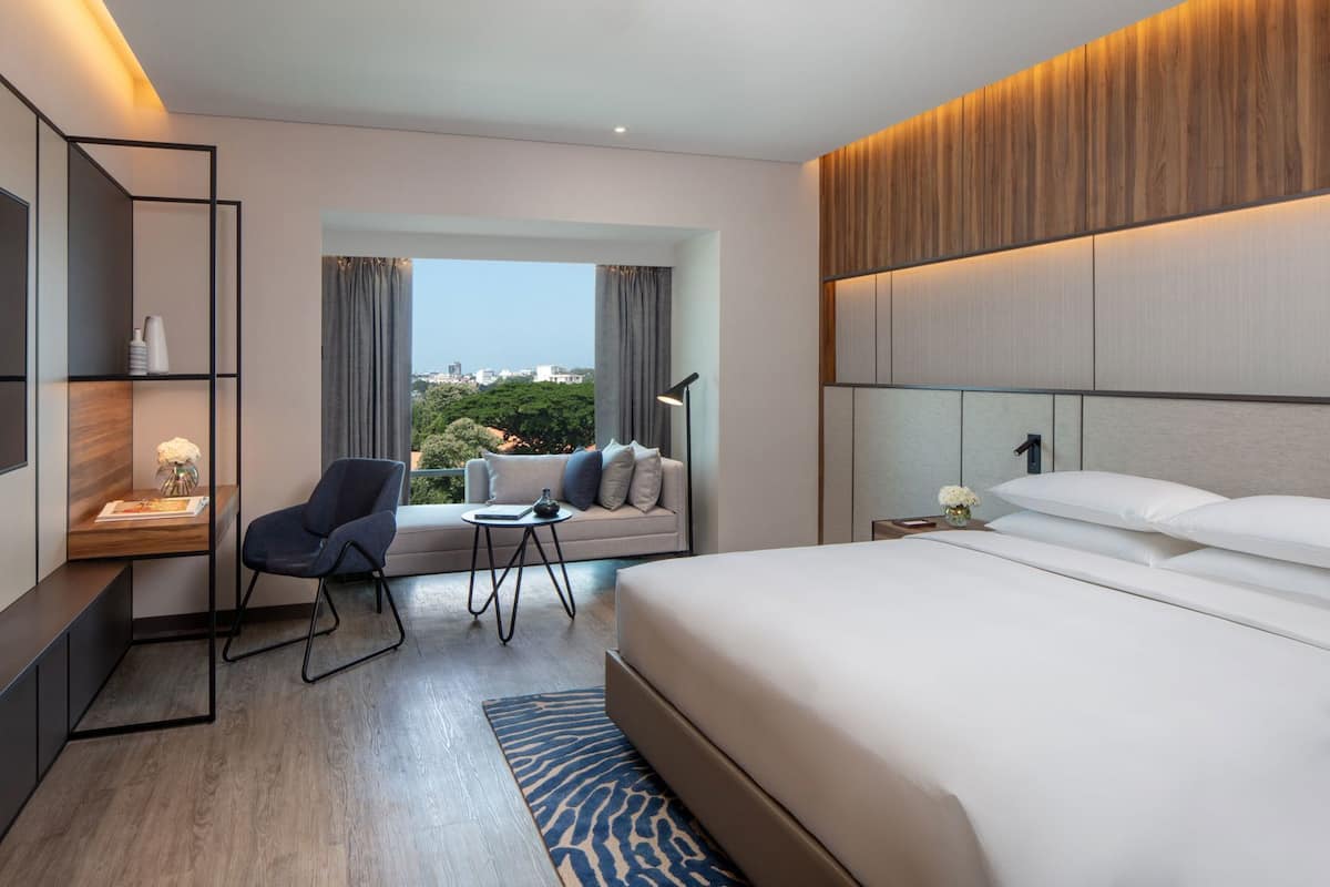 Une chambre d’hôtel moderne, dotée d’un grand lit, d’un canapé, d’un bureau et d’une chaise.