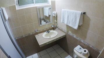 Un baño pequeño con lavamanos, espejo e inodoro.