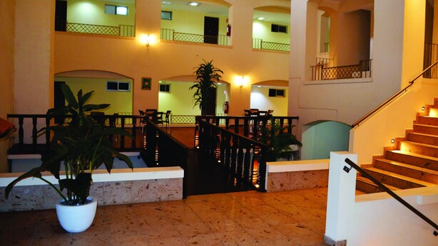 A multi-level interior with a central staircase, multiple balconies, and potted plants. - Hotel Davimar (Guamuchil)