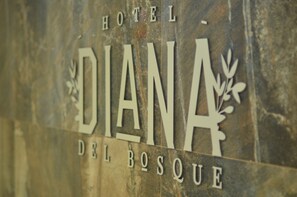 A sign with the text "HOTEL DIANA DEL BOSQUE".