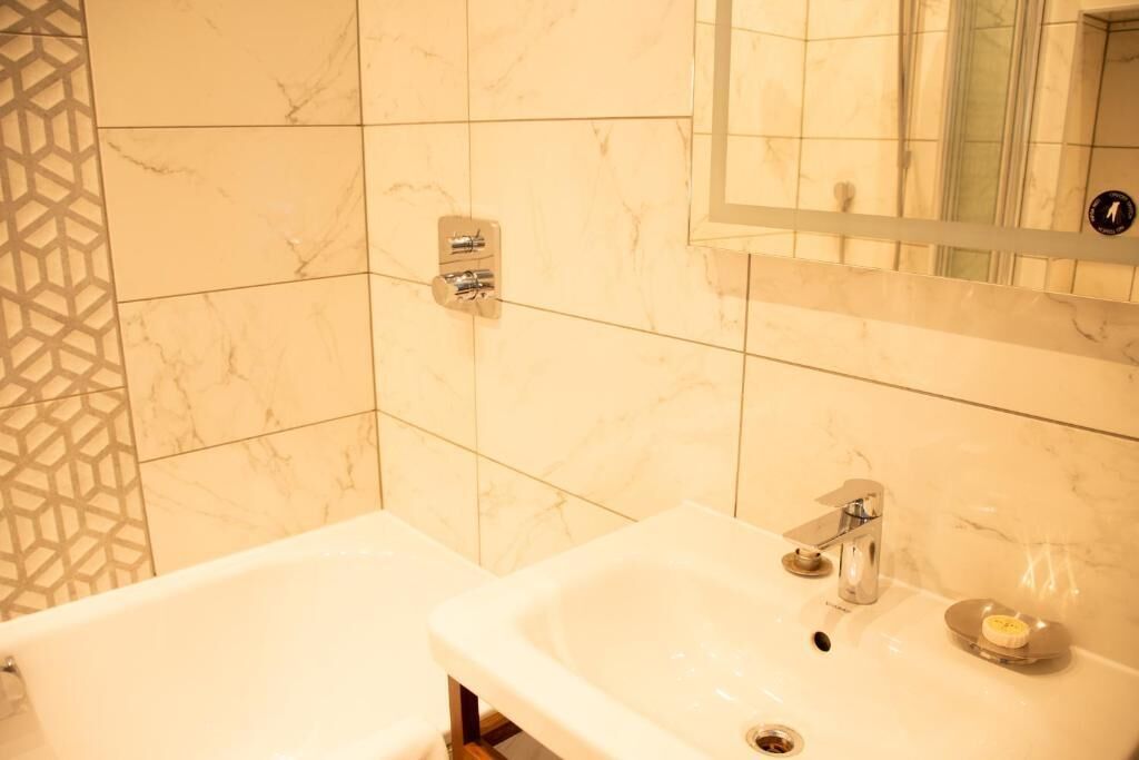 Une salle de bain avec une baignoire, un lavabo et un miroir.