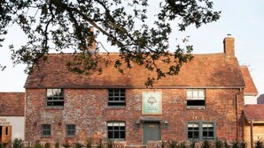Een bakstenen gebouw met een bord waarop 'The Old Inn' staat.