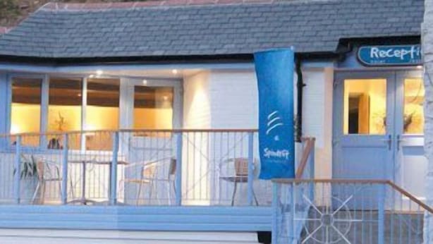 A coastal hotel with a reception area, outdoor seating, and a balcony with railings. - The Driftwood Spars (St. Agnes)