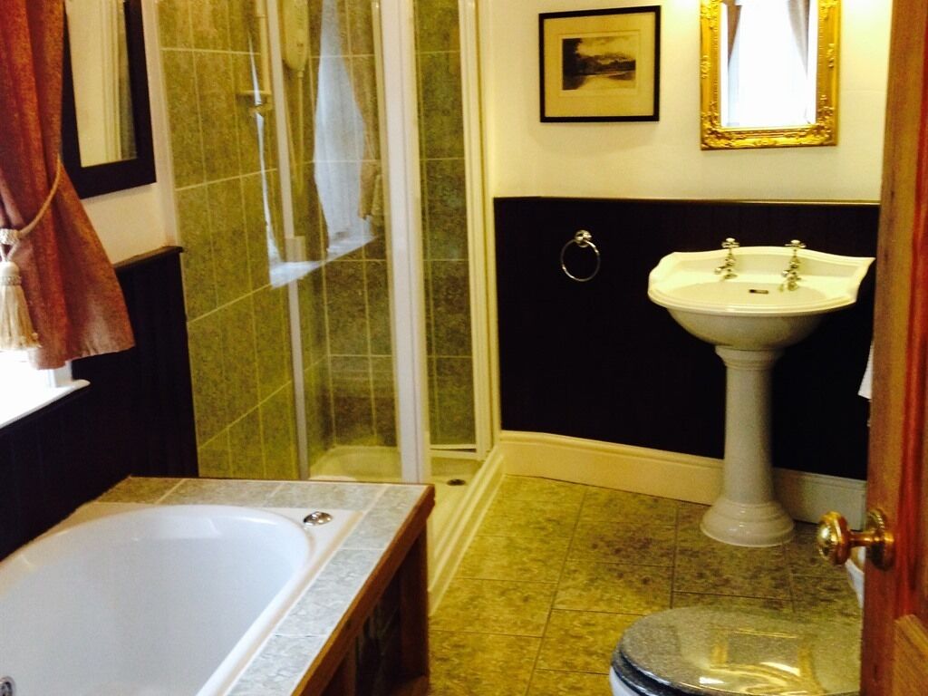 A bathroom with a bathtub, a sink, and a shower area.