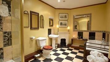 Une salle de bain avec un carrelage à motifs géométriques, des toilettes, un lavabo, un miroir et une douche.