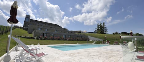 Alberca al aire libre, sombrillas en la alberca y camastros