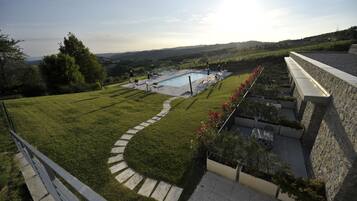 Un espace extérieur aménagé avec une piscine, des murs en pierre et un chemin pavé.