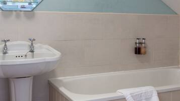 A bathroom with a white sink, a mirror, and a bathtub.