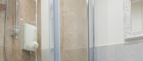 Un baño moderno con ducha envuelta en vidrio, inodoro y lavamanos.