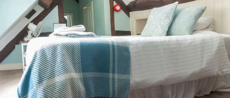 Un dormitorio con una cama, un ventilador y una puerta.