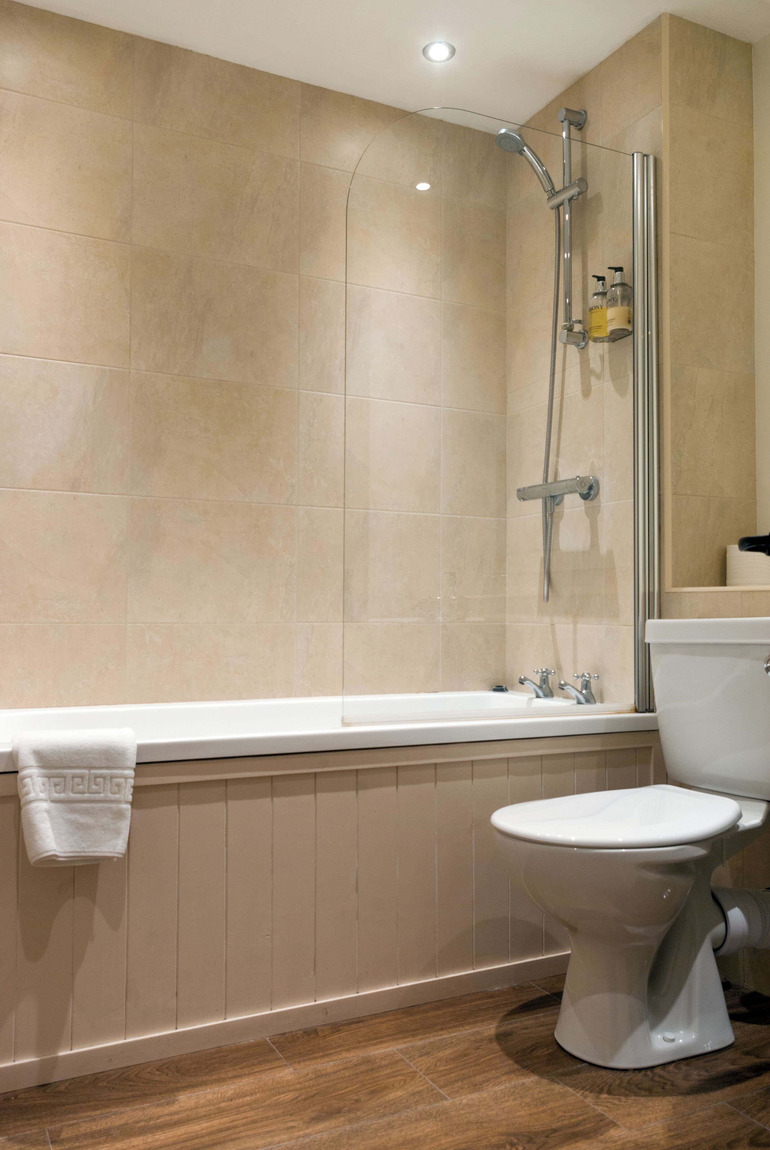 A bathroom with a bathtub, toilet, and shower.