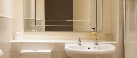 Une petite salle de bain comprenant des toilettes, un lavabo et un miroir.