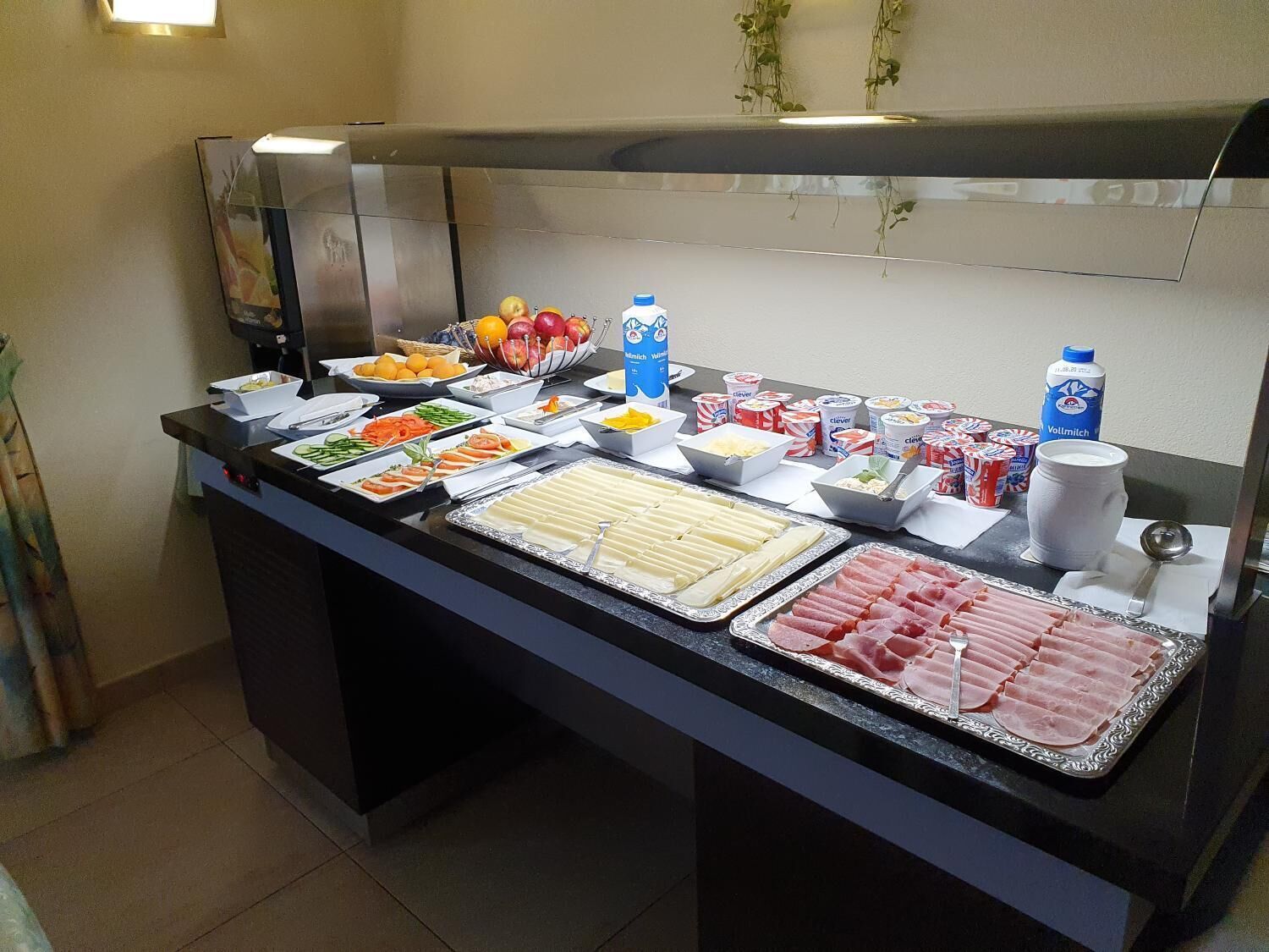 Un bufé con diversos alimentos, como frutas, quesos y embutidos.