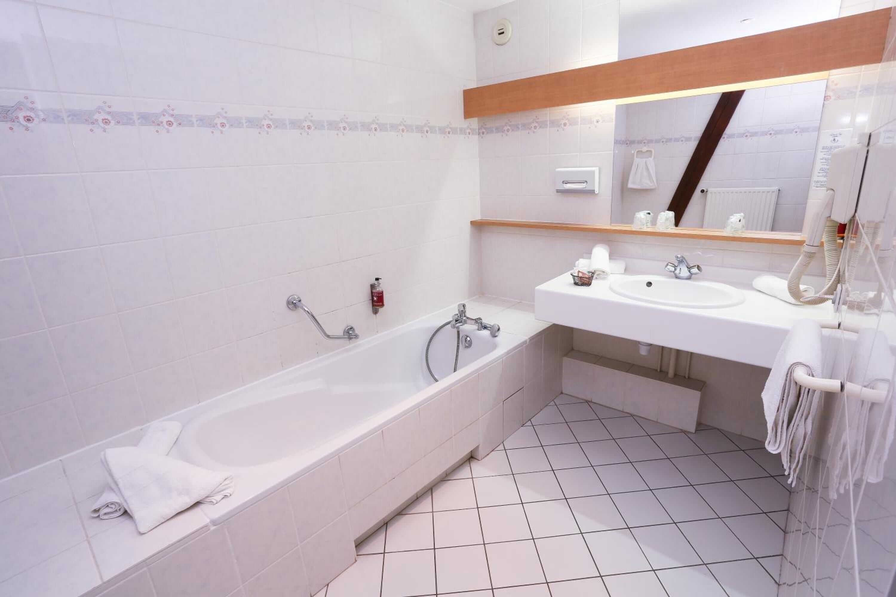 A modern bathroom with a large bathtub, a double sink vanity, and a mirror above the sink.