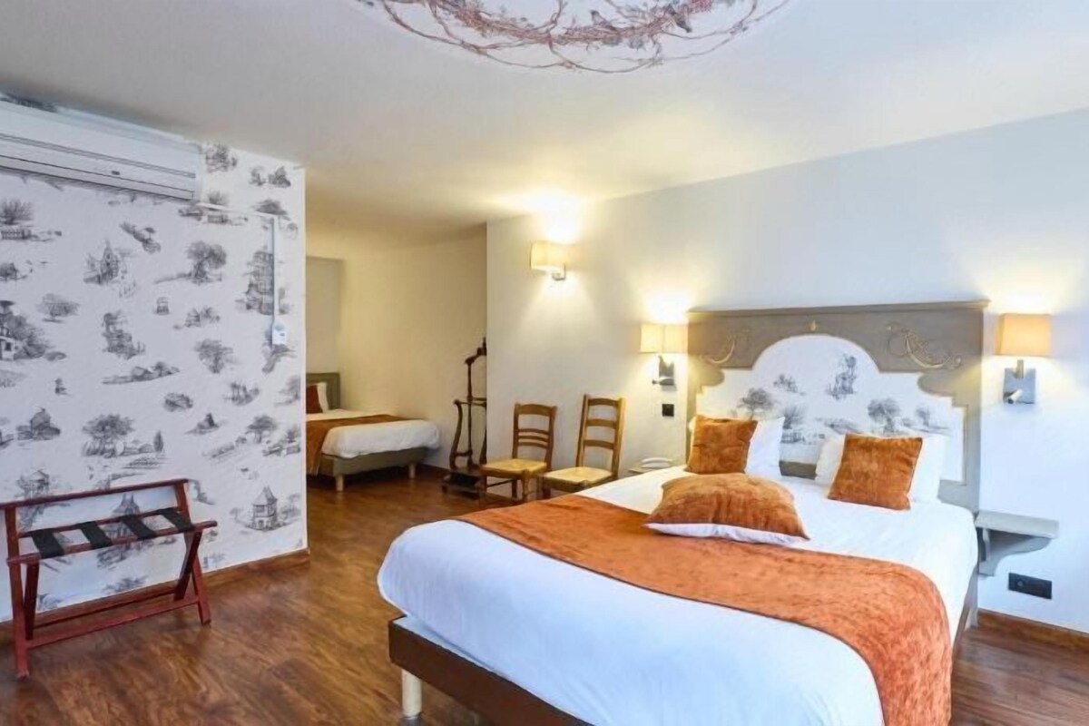 Habitación de hotel con una cama grande, dos mesitas de noche, una silla, un escritorio y un armario.