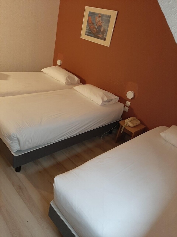 A hotel room with two single beds, a bedside table with a lamp, and a framed picture on the wall. - Cit'Hotel Primo Colmar Centre (Colmar)