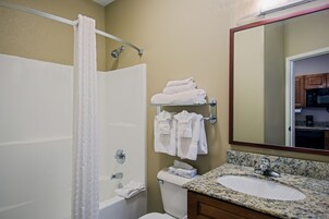 Un baño con bañera, inodoro, lavabo y espejo.