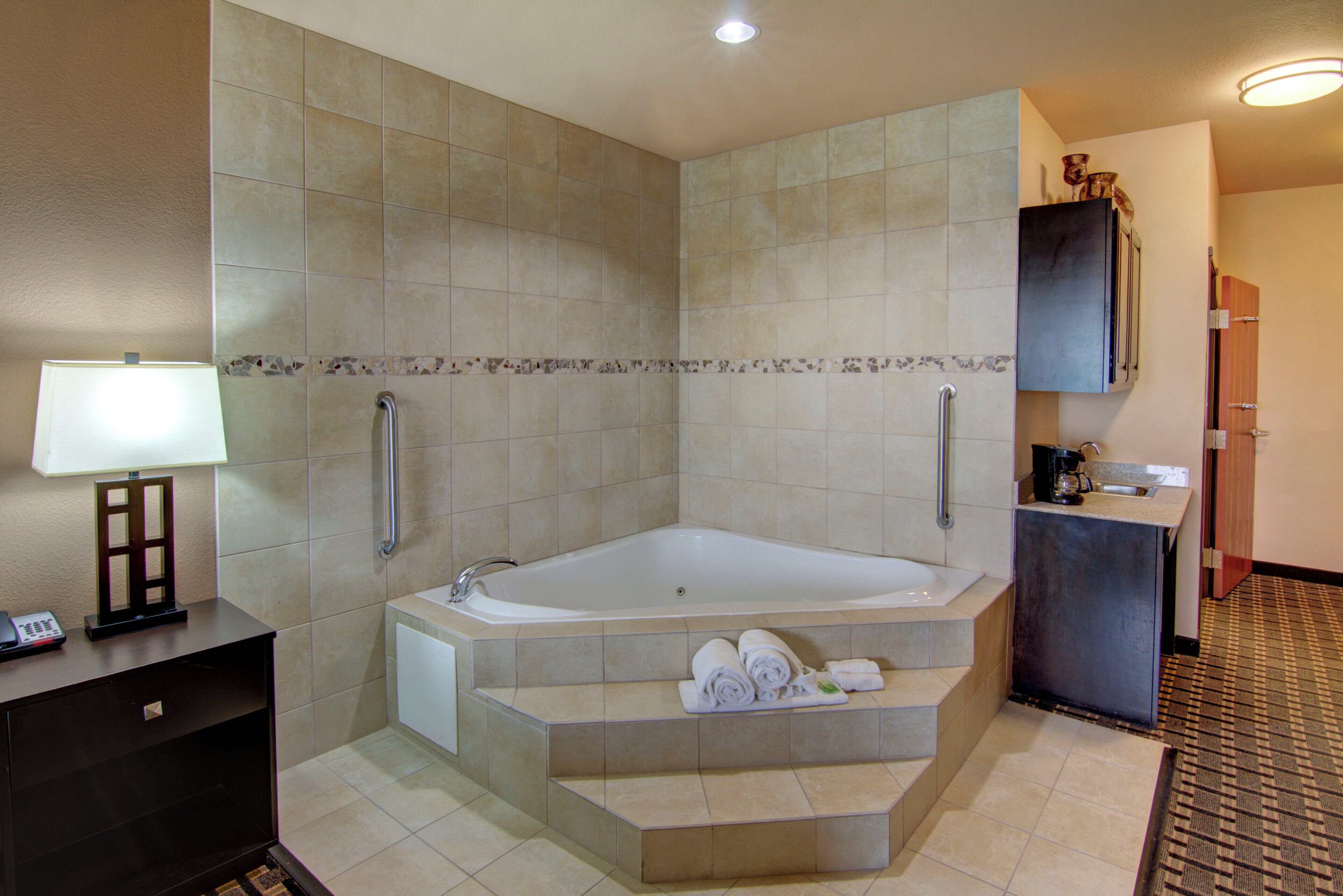 A hotel bathroom with a bathtub, a toilet, a sink, and a mirror.