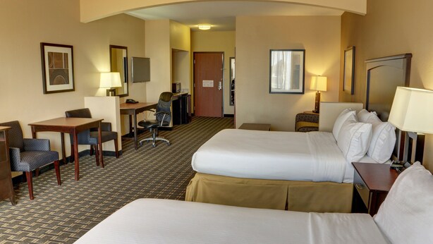 A hotel room with two beds, a desk, a chair, a TV, and a door leading to another room. - Holiday Inn Express Hotel & Suites Huntsville by IHG (Huntsville)