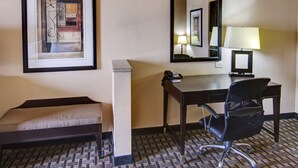 A hotel room with a desk, chair, bedside table, lamp, and a framed abstract artwork. - Holiday Inn Express Hotel & Suites Huntsville by IHG (Huntsville)