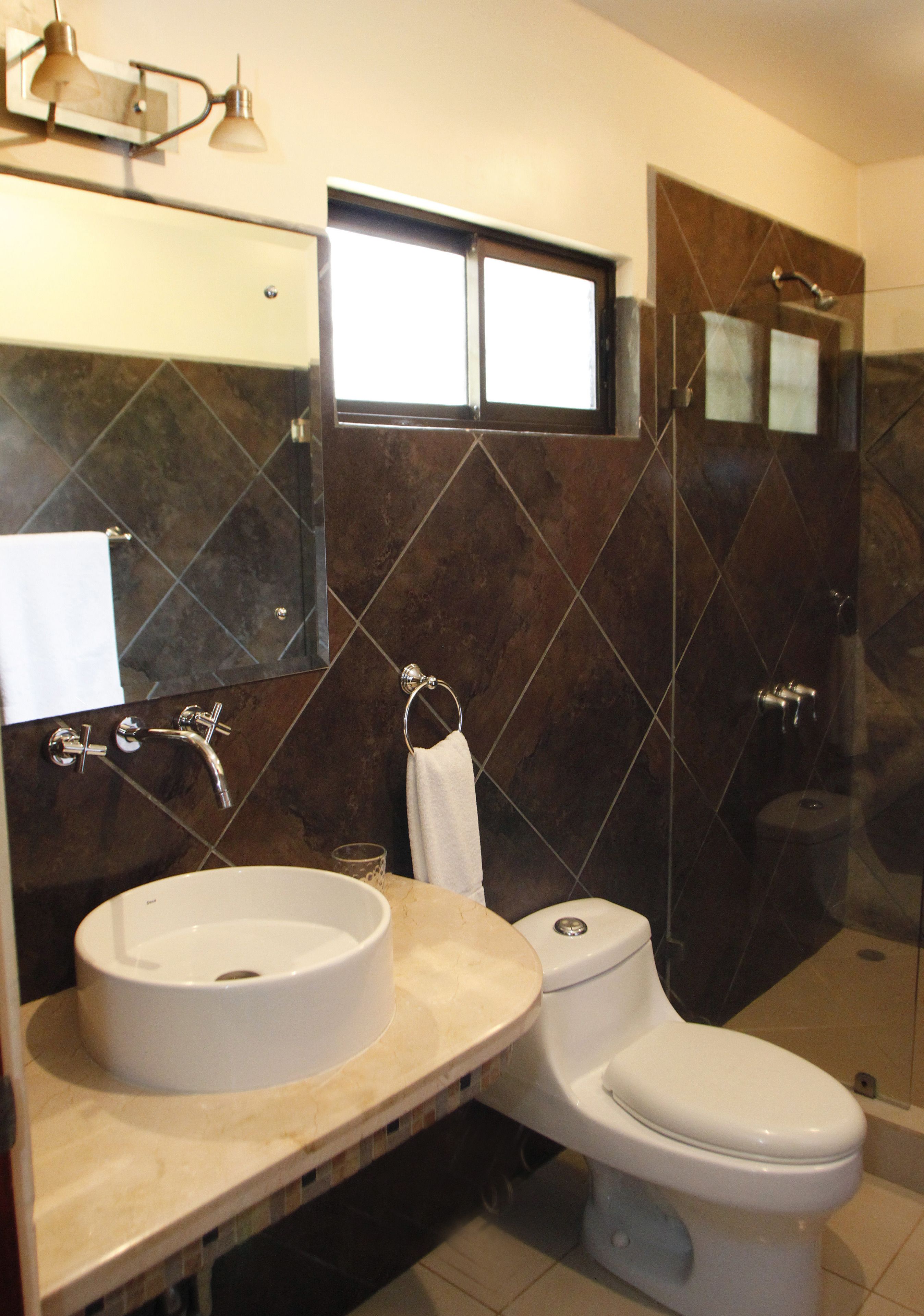 A bathroom with a sink, toilet, and shower.