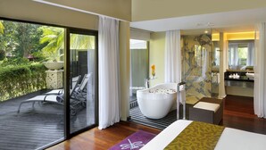 A modern hotel room with a large bed, a bathtub, and a balcony with outdoor furniture. - Thistle Port Dickson (Port Dickson)