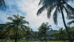 A pathway leading to a building surrounded by palm trees. - Thistle Port Dickson (Port Dickson)