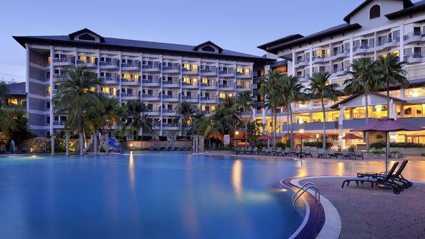 A hotel with a large swimming pool, multiple balconies, and palm trees. - Thistle Port Dickson (Port Dickson)