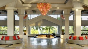 A spacious lobby with a reception desk, large columns, and a chandelier. - Thistle Port Dickson (Port Dickson)