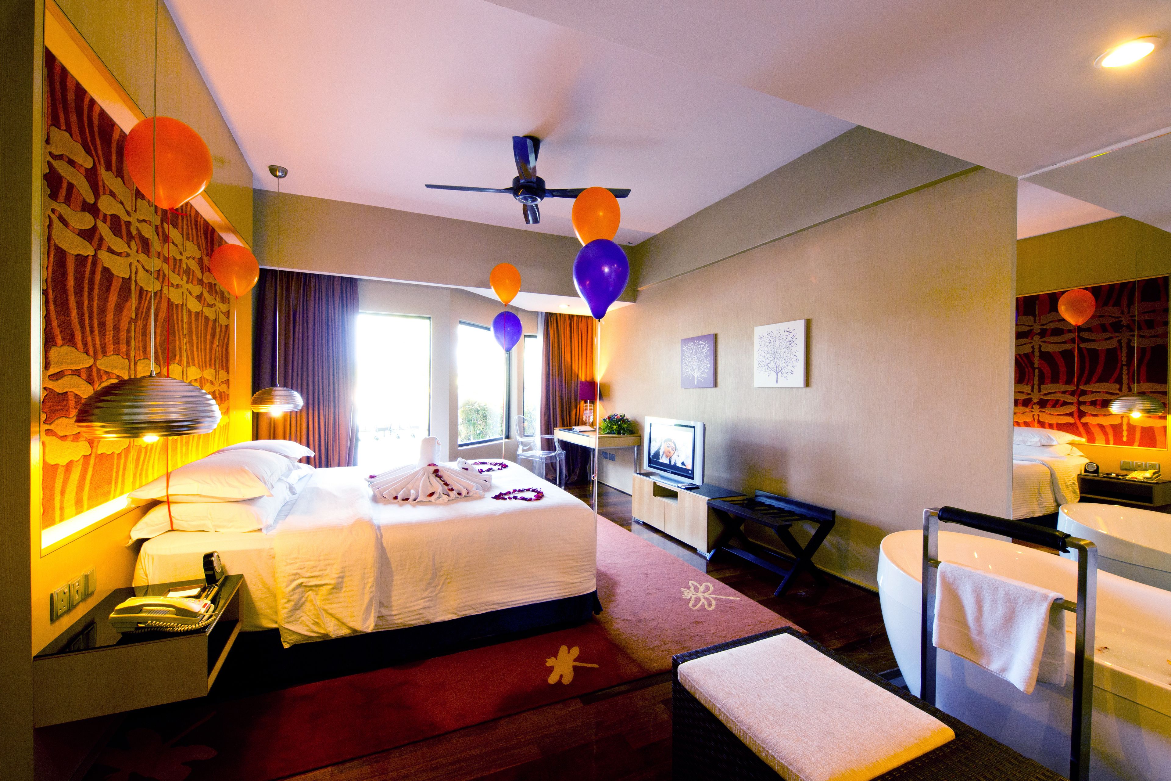 A hotel room with a bed, a desk, a TV, and a bathroom.