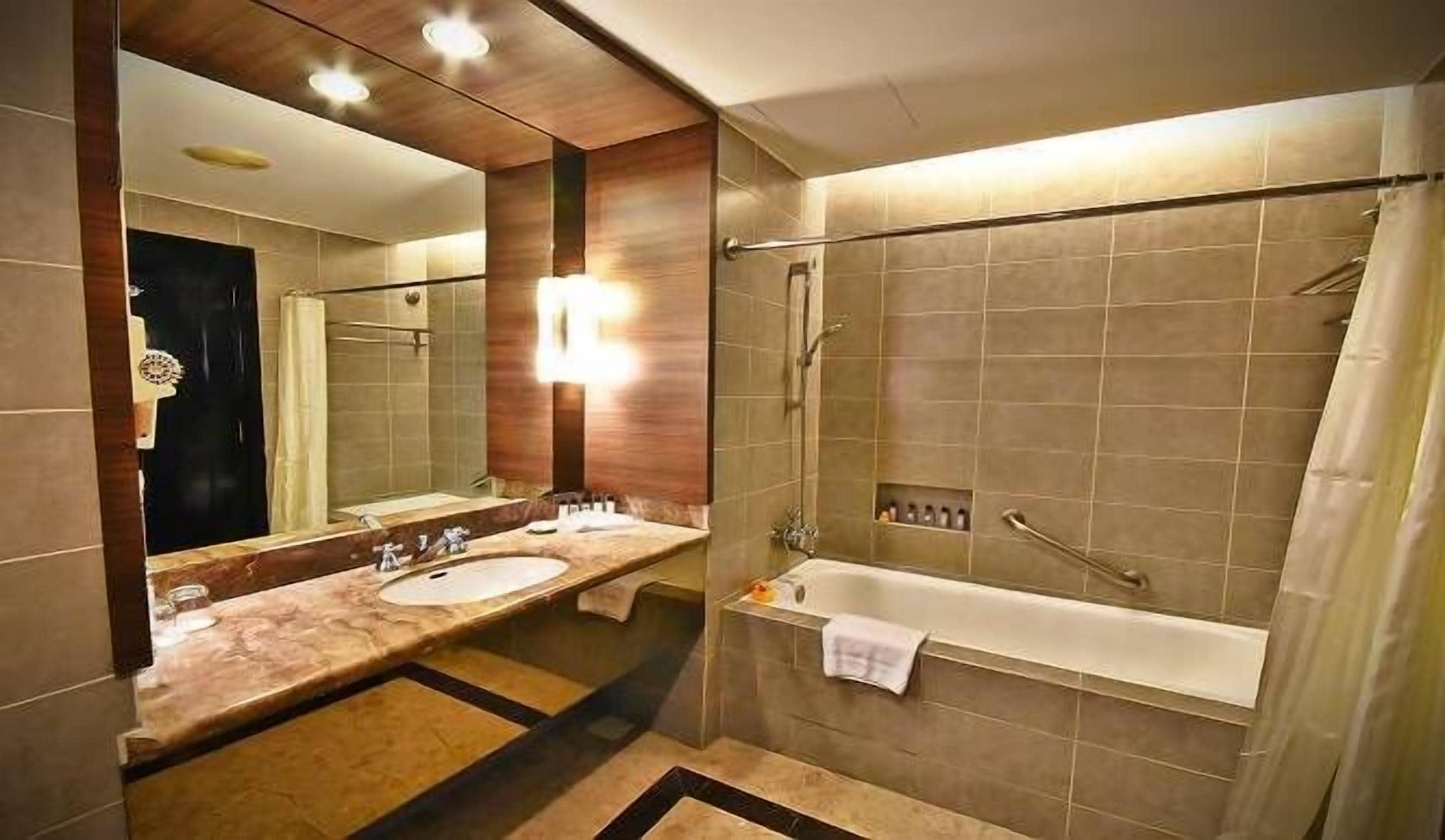 Een moderne badkamer met twee wastafels, een bad en een douche.