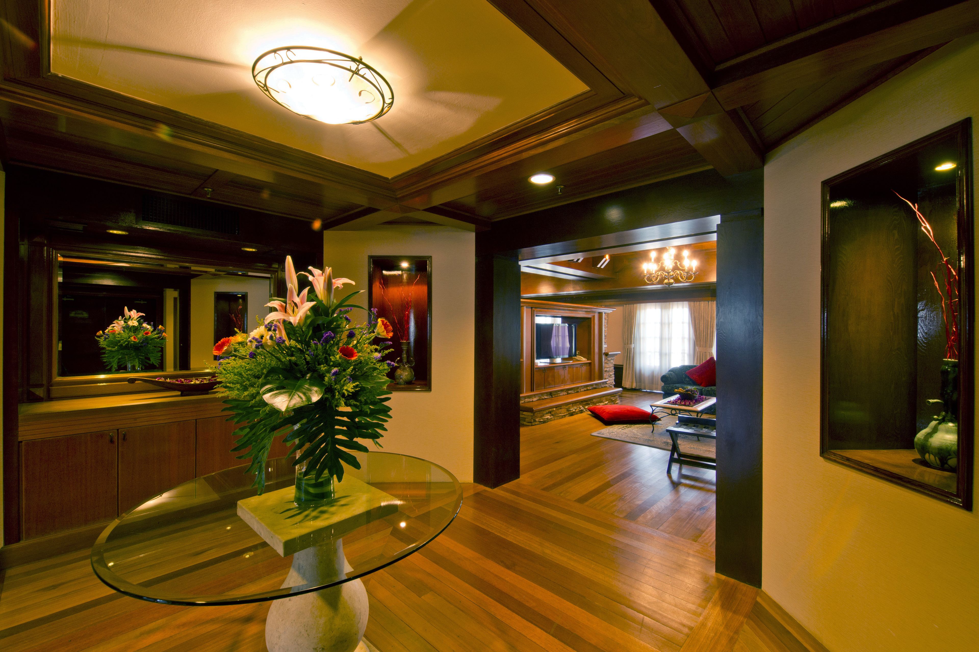 A modern interior with a glass table, wooden flooring, and a dining area.