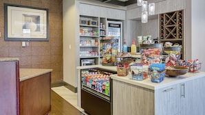 A self-service beverage station with a refrigerated section, snack and food items, and a wine rack. - Hilton Garden Inn Phoenix Airport North (Phoenix)