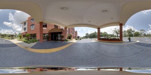 A building with a brick facade, a covered entrance, and a paved courtyard. - Comfort Inn & Suites Midway - Tallahassee West (Midway)
