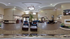 A spacious lobby with a curved ceiling, a reception desk, seating area, and a large mirror. - Comfort Inn & Suites Midway - Tallahassee West (Midway)