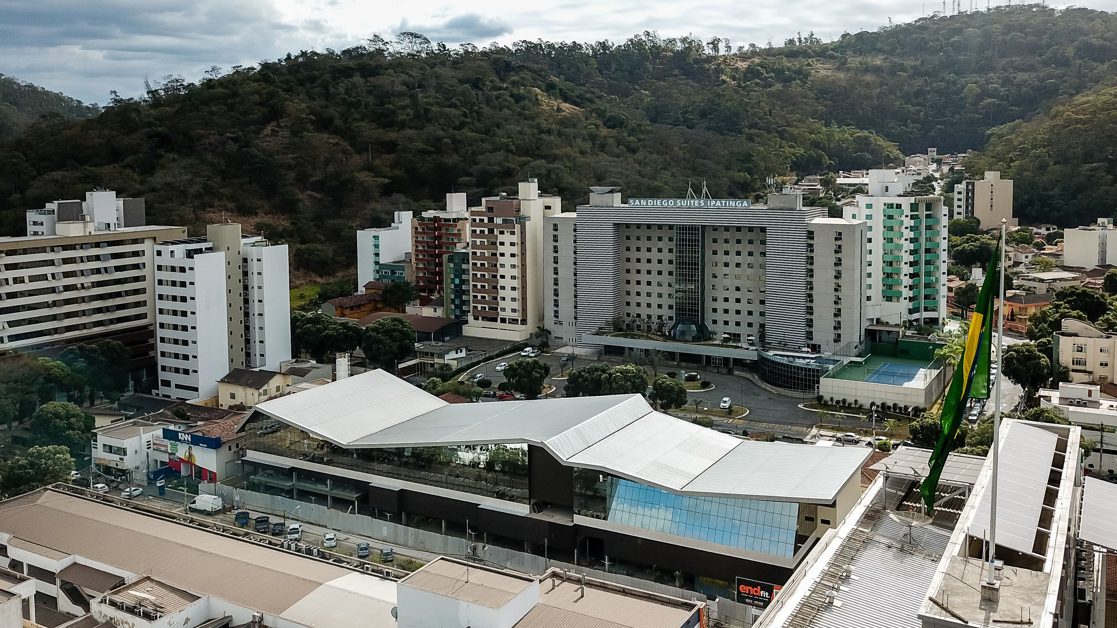 Un moderno complejo hotelero con varias torres, una zona de estacionamiento y vistas a un paisaje montañoso.