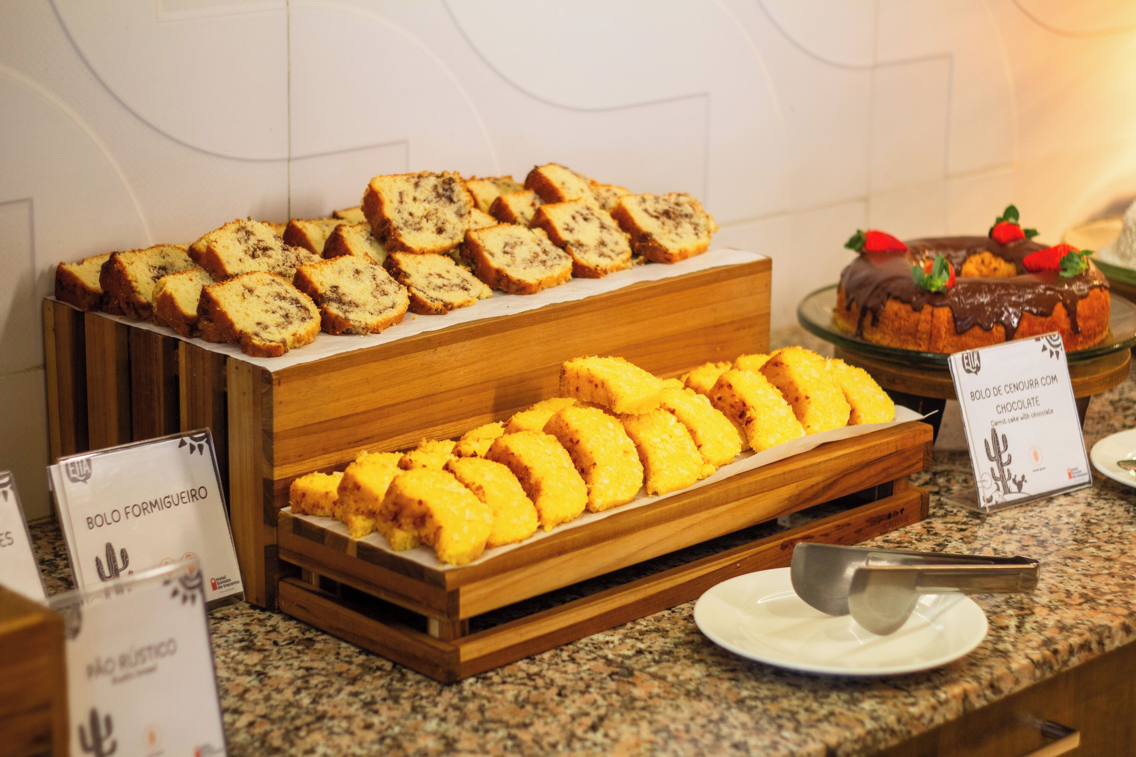 A buffet with various food items including bread and a chocolate dessert.