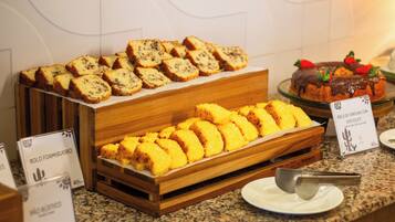 A buffet with various food items including bread and a chocolate dessert.
