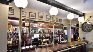 A bar area with a counter, multiple taps, and a clock on the wall. - The George Hotel, Crewkerne (Crewkerne)