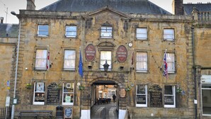 A historic building with multiple signs for 'The George Hotel' and 'The George Hotel House'. - The George Hotel, Crewkerne (Crewkerne)