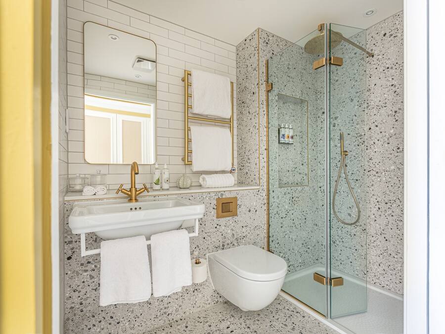 A modern bathroom with a freestanding bathtub, a glass-enclosed shower, and a white toilet.