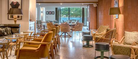 Amplia sala de estar con muebles de mimbre, una mesa de comedor y vistas al exterior.