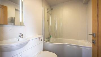 Un baño con lavamanos, inodoro y cabina de ducha.