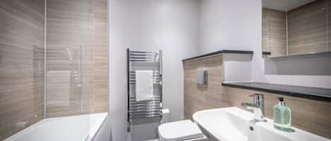Un baño moderno con bañera, inodoro y lavamanos.