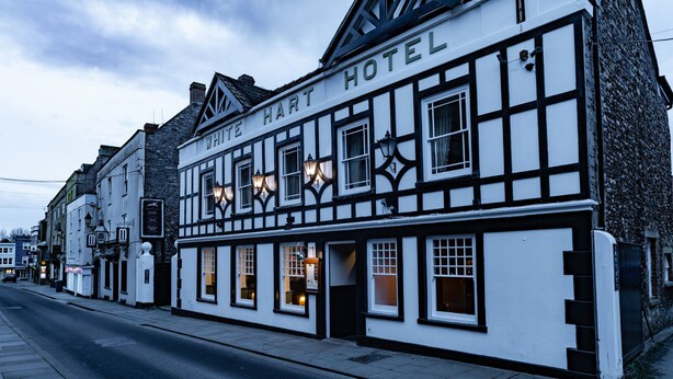 A traditional half-timbered building with a sign reading "White Hart Hotel". - White Hart Inn (Wells)