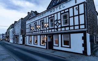 Un edificio tradicional con entramado de madera y un letrero que dice "White Hart Hotel".