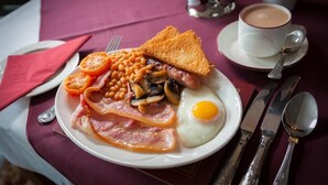 A breakfast plate with toast, beans, mushrooms, bacon, a fried egg, and tomatoes. - Potters Mooring Guest House Hotel (Teignmouth)