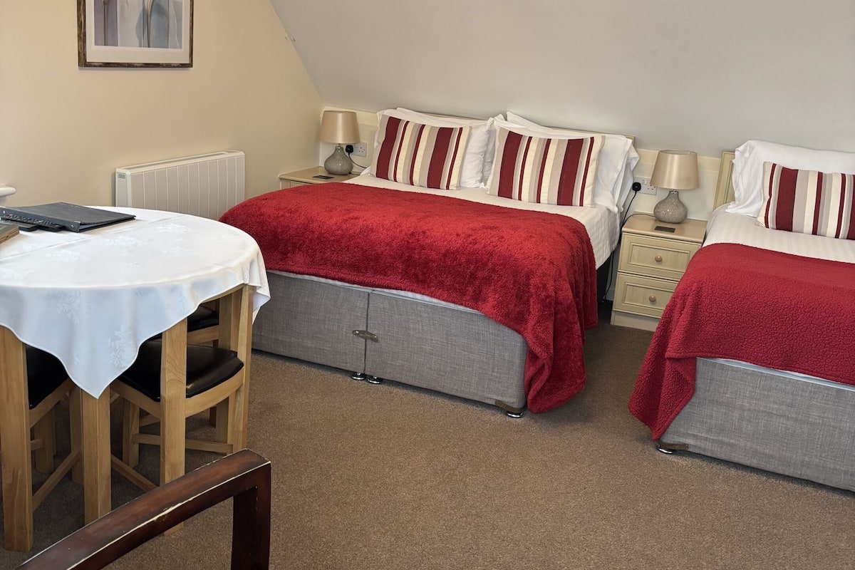 Une chambre confortable avec deux lits, une table et une chaise.