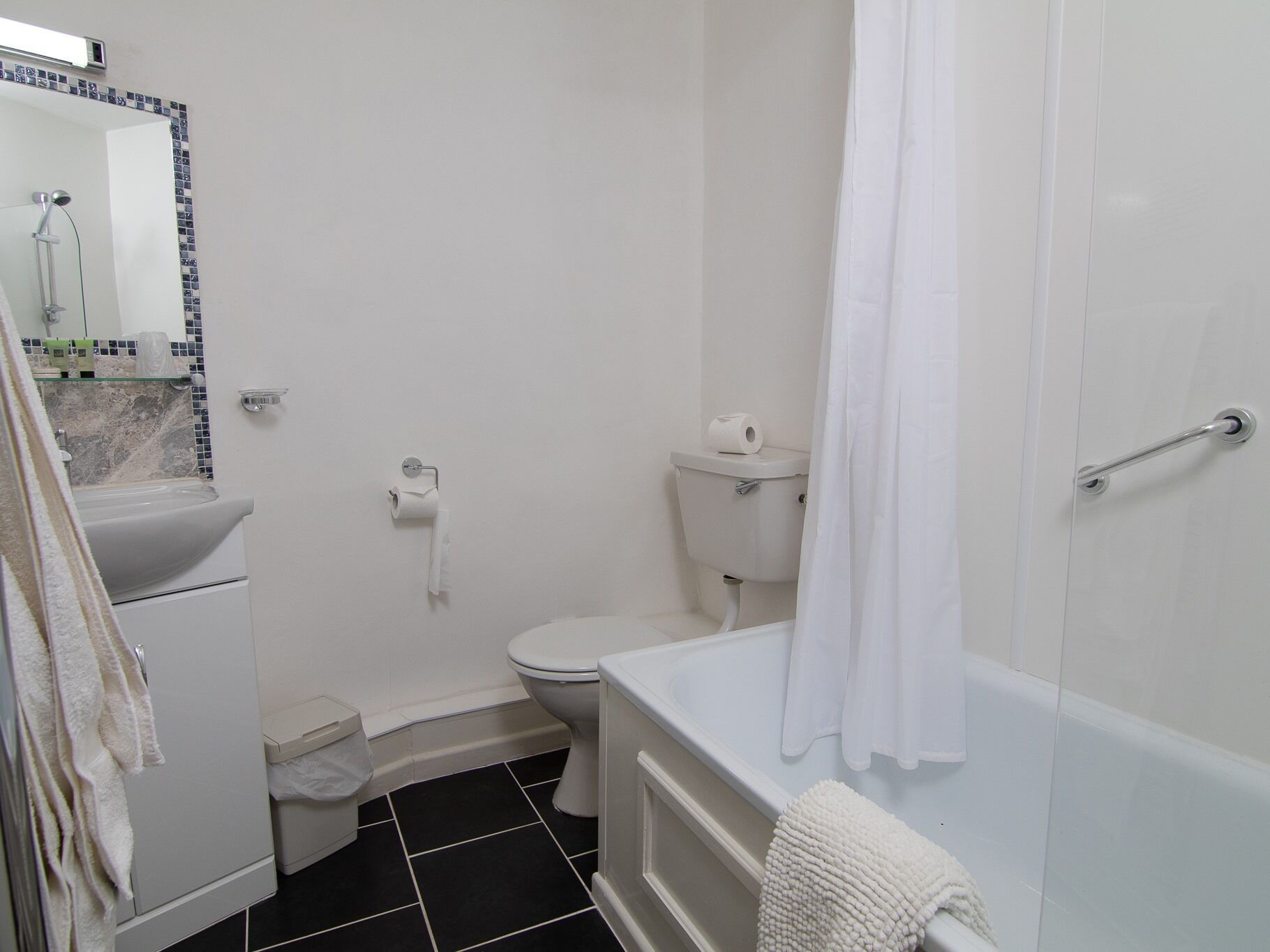 A bathroom with a toilet, sink, and bathtub.