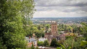 A historic church with a prominent tower, surrounded by lush greenery and residential buildings.